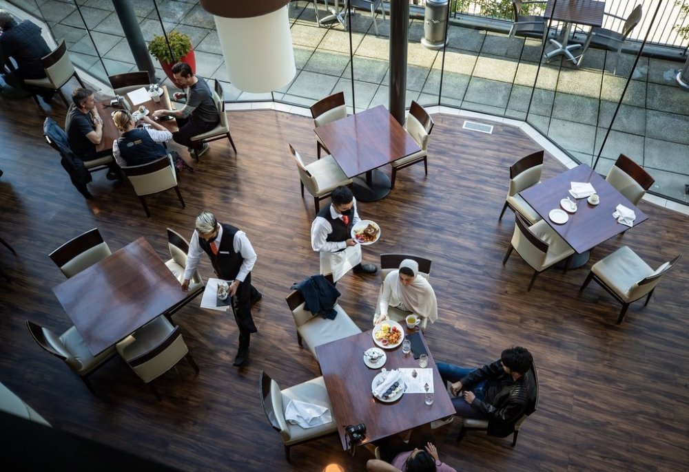 A server brings food to a table as people dine at a restaurant in Vancouver on Tuesday, Sept. 21, 2021. THE CANADIAN PRESS/Darryl Dyck