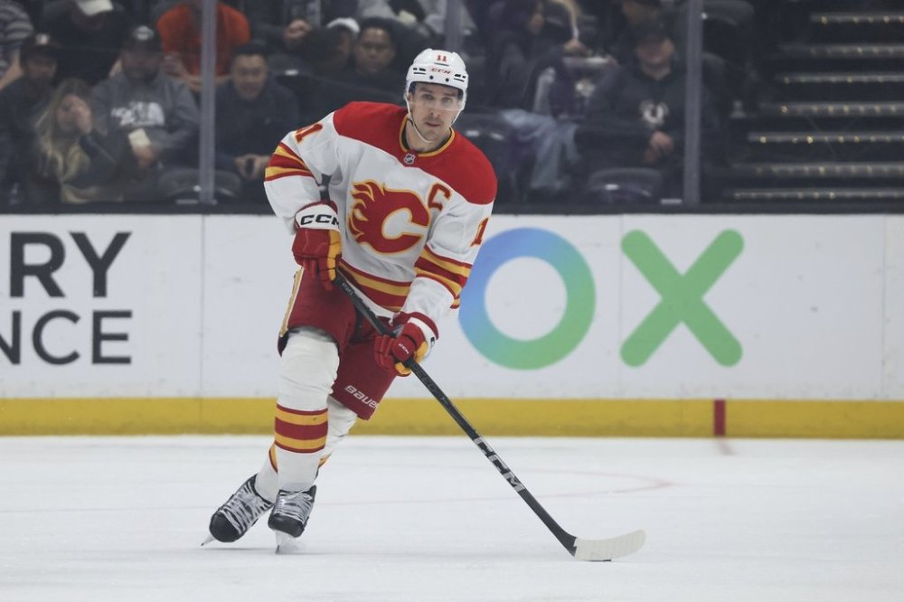 Calgary Flames center Mikael Backlund controls the puck during the second period of an NHL hockey game against the Anaheim Ducks, Wednesday, April 9, 2025, in Anaheim, Calif. (AP Photo/Etienne Laurent)
