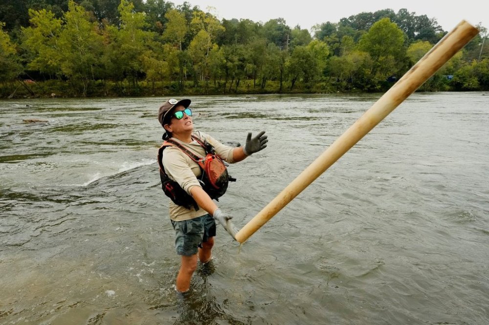 Leslie Beninato, river cleanup logistics manager of MountainTrue, removes a PVC pipe from the French Broad River on Wednesday, Sept. 17, 2025, in Asheville, N.C. (AP Photo/Chris Carlson)