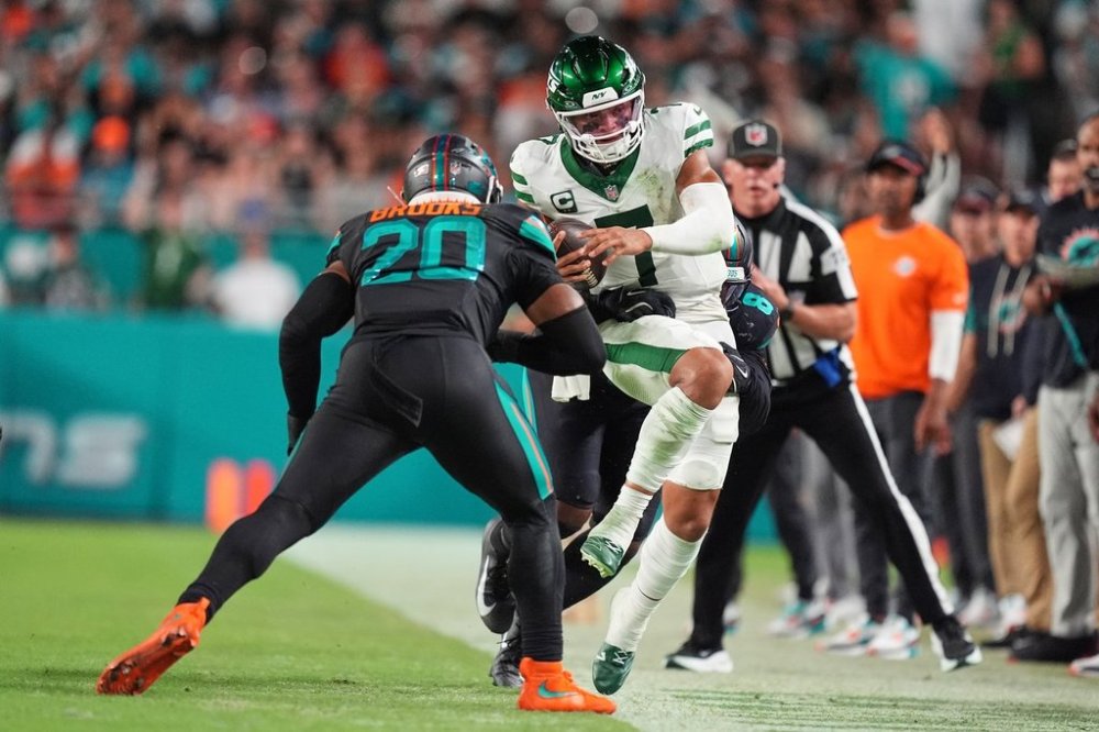 New York Jets quarterback Justin Fields (7) is knocked out of bounds by Miami Dolphins linebacker Jordyn Brooks (20) and Matthew Judon, rear, in the second half of an NFL football game, Monday, Sept. 29, 2025, in Miami Gardens, Fla. (AP Photo/Rebecca Blackwell)