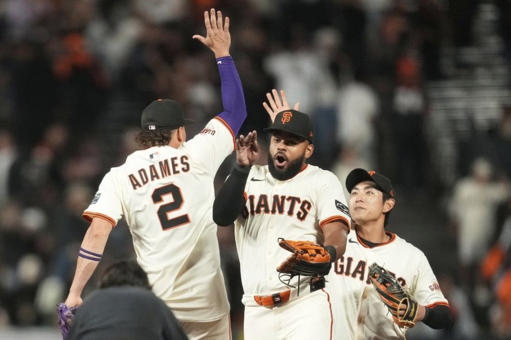 San Francisco Giants' Willy Adames (2) celebrates with Heliot Ramos, middle, and Jung Hoo Lee after a baseball game against the Arizona Diamondbacks in San Francisco, Monday, Sept. 8, 2025. (AP Photo/Jeff Chiu)