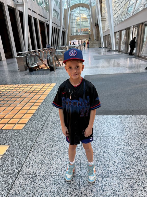 Brady Forma, a young Blue Jays fan visiting the city from Calgary, poses for a photo with his new jersey in this handout photo. THE CANADIAN PRESS/Handout - David Forma (Mandatory Credit)