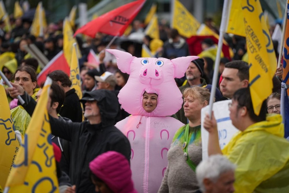 Striking Canada Post employee Raylene Marshall wears a pig costume as she joins B.C. General Employees' Union (BCGEU) members and other supporters at a rally in Vancouver, on Wednesday, Oct. 1, 2025. THE CANADIAN PRESS/Darryl Dyck