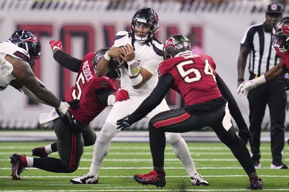 Houston Texans quarterback C.J. Stroud (7) attempts to escape pressure from Tampa Bay Buccaneers linebacker Haason Reddick (5) and Lavonte David (54) in the second half of an NFL football game Monday, Sept. 15, 2025, in Houston, Texas. (AP Photo/Eric Christian Smith)