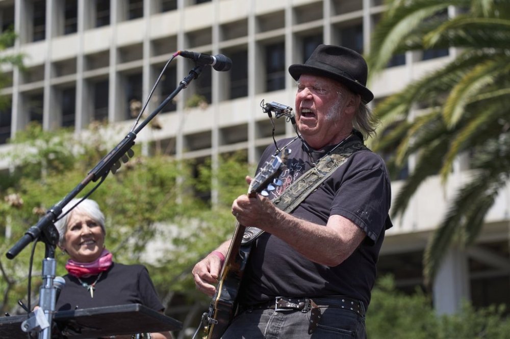 Neil Young performs as he is joined by Joan Baez during a