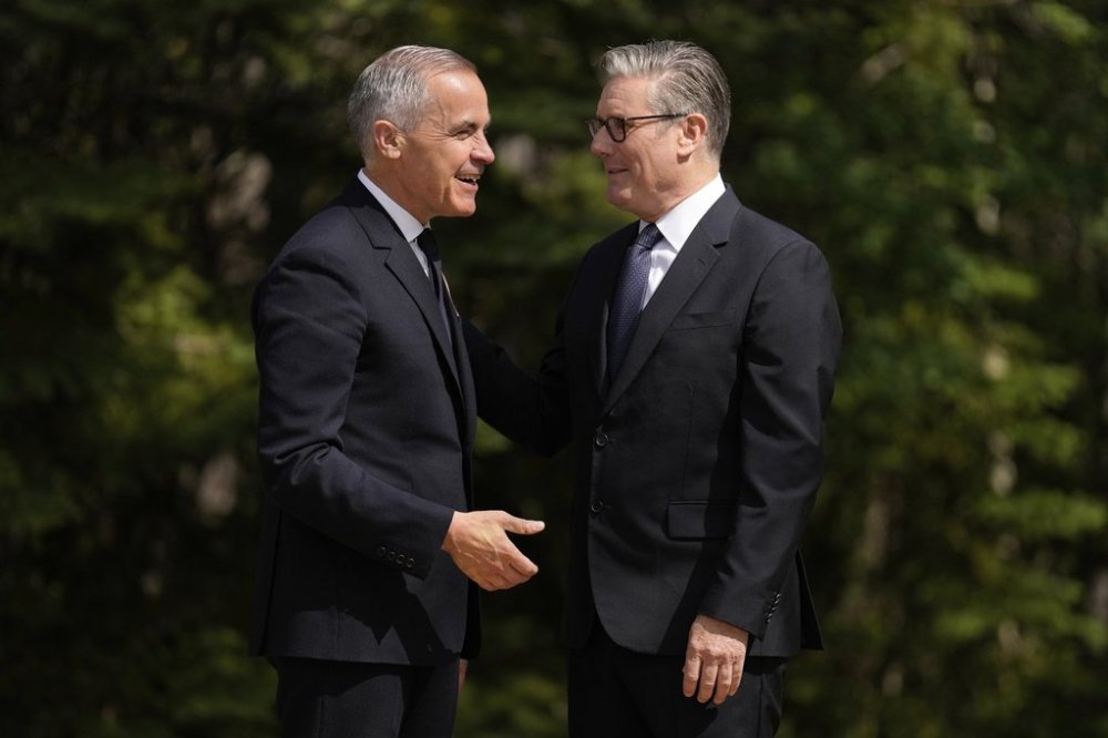 Prime Minister Mark Carney, left, greets Britain's Prime Minister Keir Starmer during the official welcome at the G7 Summit on Monday, June 16, 2025, in Kananaskis, Alta. (AP Photo/Mark Schiefelbein)