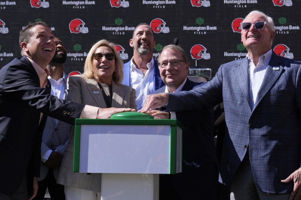 FILE - From left, Brant Standridge of Huntington Bank, Dee Haslam, Cleveland Browns owner, Steve Steinour of Huntington Bank and Jimmy Haslam, Cleveland Browns owner laugh after pressing a button to display