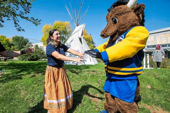 Mackaila Bruce-Tapley (left), Indigenous Residence Advisor and second-year health sciences student, and Billy the Bison play an Indigenous game at the University of Manitoba Indigenous Orientation on Sept. 10. (Mikaela MacKenzie / Free Press files)