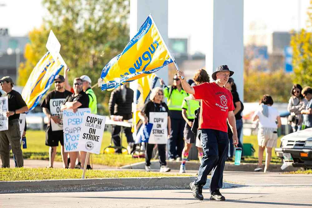 MIKAELA MACKENZIE / FREE PRESS
Postal worker Tyler Oswald pickets at the Canada Post mail processing plant on Wellington Avenue in Winnipeg on Thursday.