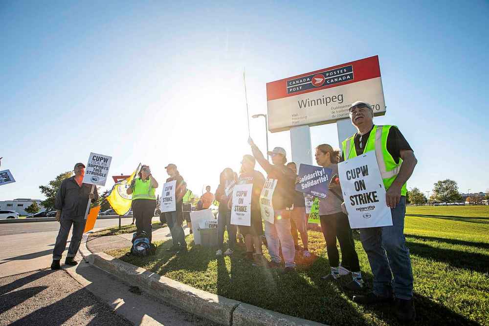MIKAELA MACKENZIE / FREE PRESS
Postal workers picket at the Canada Post mail processing plant on Wellington Avenue in Winnipeg on Thursday.