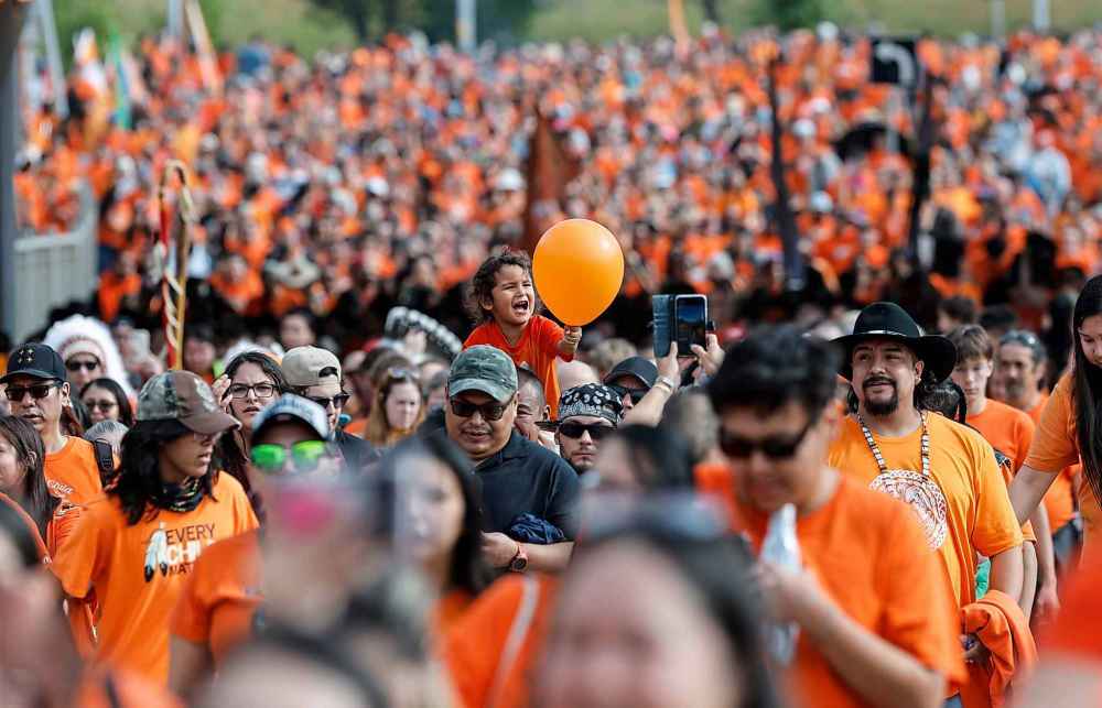 People take part in the Orange Shirt Healing Walk and Powwow in Winnipeg Tuesday.