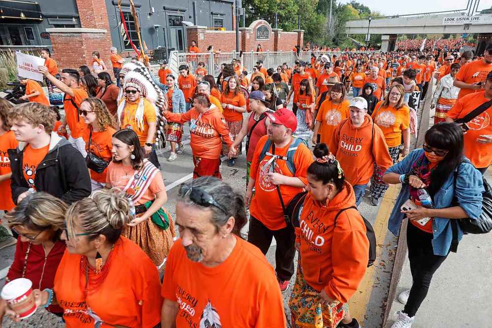 People take part in the Orange Shirt Healing Walk and Powwow in Winnipeg Tuesday.