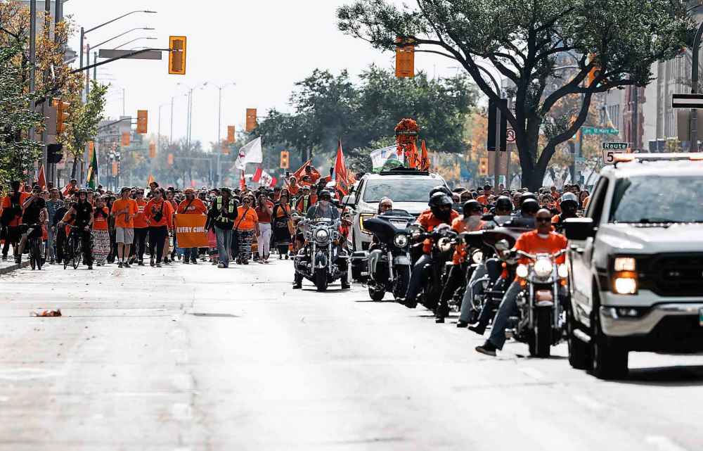 People take part in the Orange Shirt Healing Walk and Powwow in Winnipeg Tuesday.