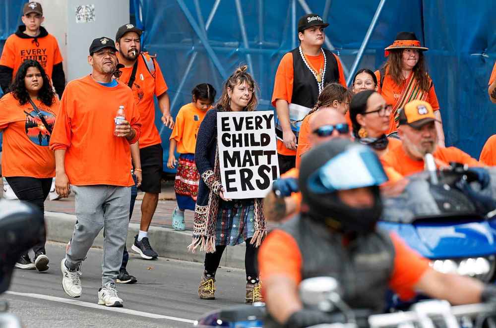 People take part in the Orange Shirt Healing Walk and Powwow in Winnipeg Tuesday.