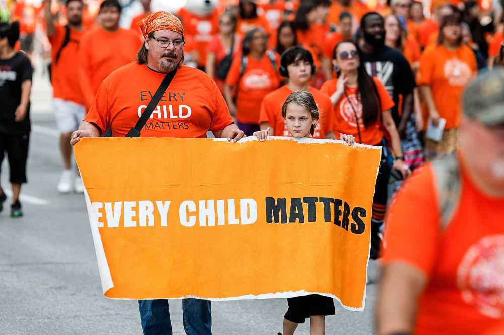 People take part in the Orange Shirt Healing Walk and Powwow in Winnipeg Tuesday.