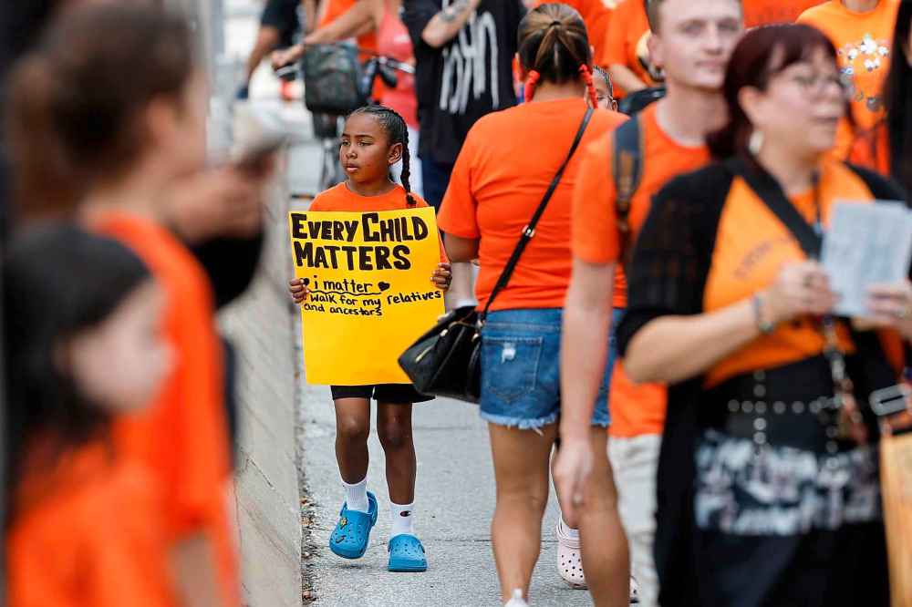People take part in the Orange Shirt Healing Walk and Powwow in Winnipeg Tuesday.