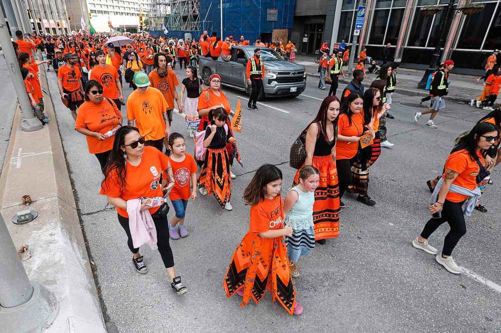 People take part in the Orange Shirt Healing Walk and Powwow in Winnipeg Tuesday.