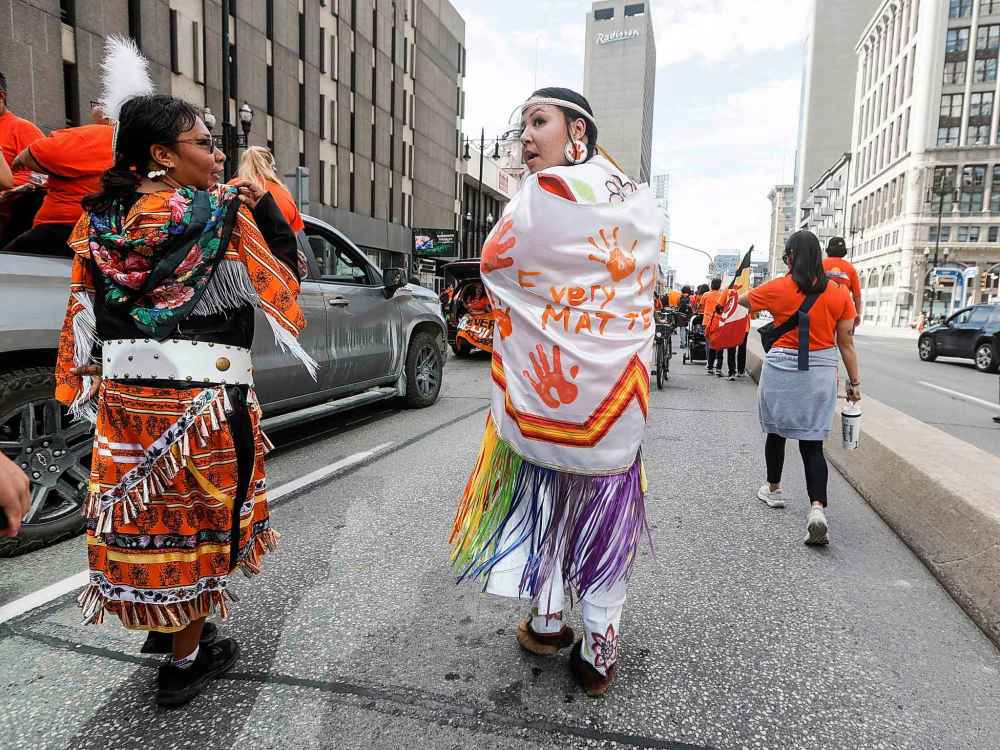 People take part in the Orange Shirt Healing Walk and Powwow in Winnipeg Tuesday.