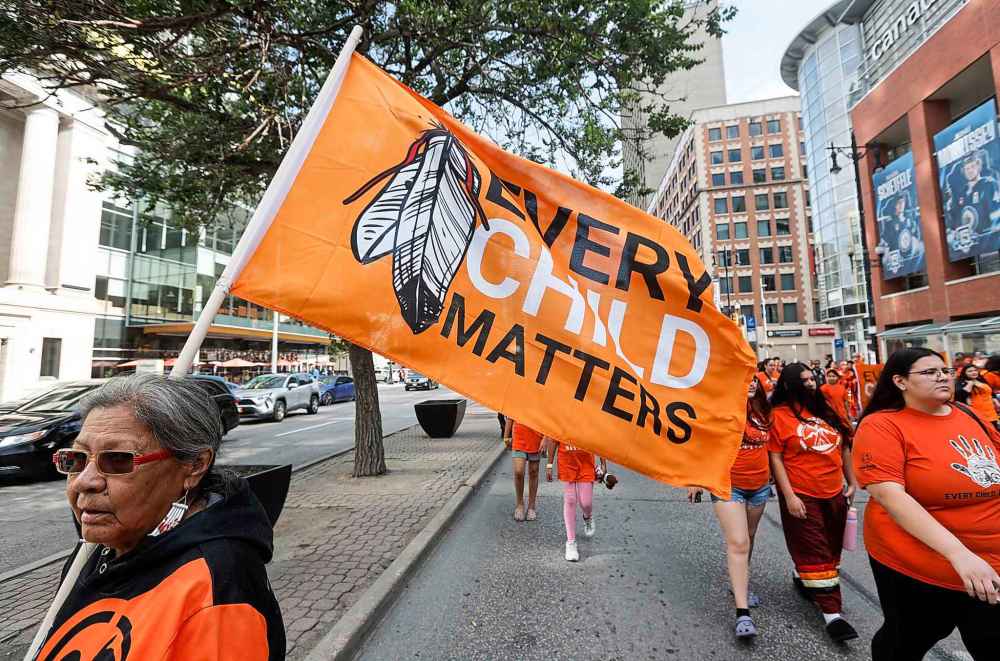People take part in the Orange Shirt Healing Walk and Powwow in Winnipeg Tuesday.