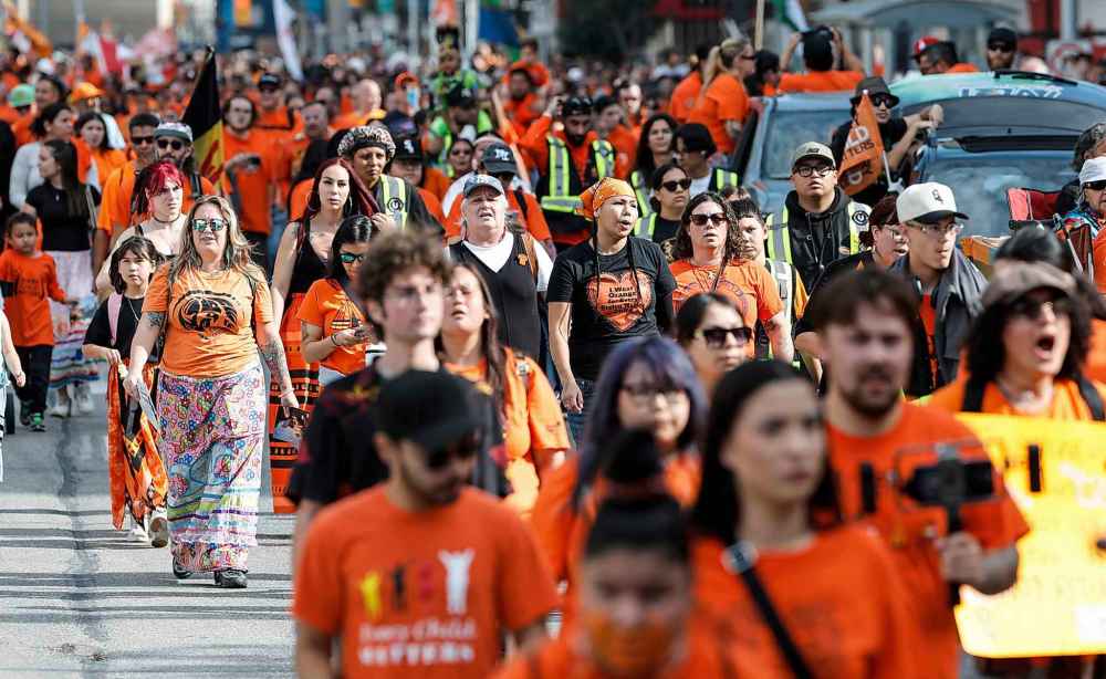 People take part in the Orange Shirt Healing Walk and Powwow in Winnipeg Tuesday.