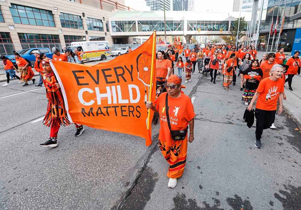 People take part in the Orange Shirt Healing Walk and Powwow in Winnipeg Tuesday.