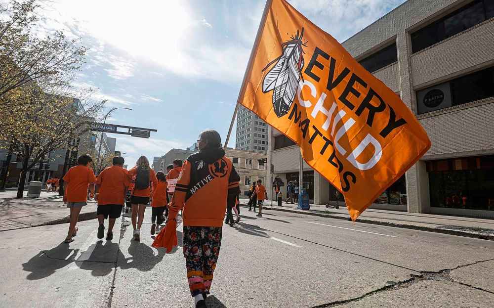 People take part in the Orange Shirt Healing Walk and Powwow in Winnipeg Tuesday.