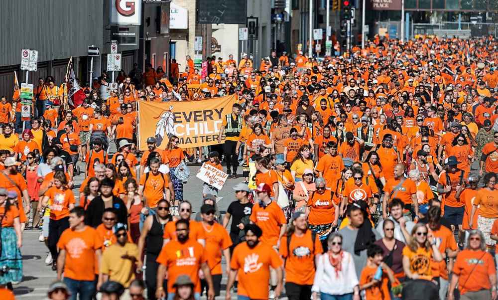 People take part in the Orange Shirt Healing Walk and Powwow in Winnipeg Tuesday.