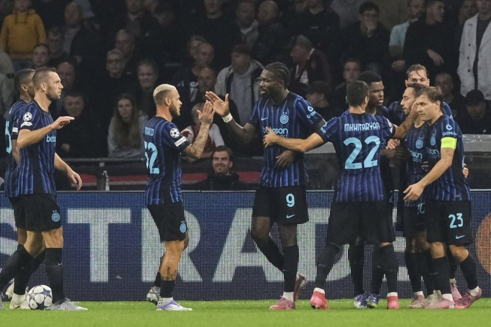 Inter Milan players celebrate with Inter Milan's Marcus Thuram, number 9, after he scored his side's first goal during a Champions League opening phase soccer match between Ajax and Inter Milan at the Johan Cruyff ArenA in Amsterdam, Netherlands, Wednesday, Sept. 17, 2025. (AP Photo/Patrick Post)