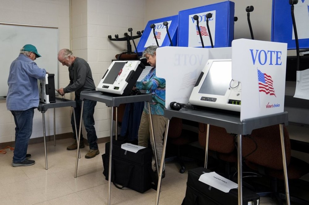 FILE - Poll workers set up ballot-marking machines at an early in-person voting site at Asheville-Buncombe Technical Community College, Wednesday, Oct. 16, 2024, in Marshall, N.C. (AP Photo/Stephanie Scarbrough,File)