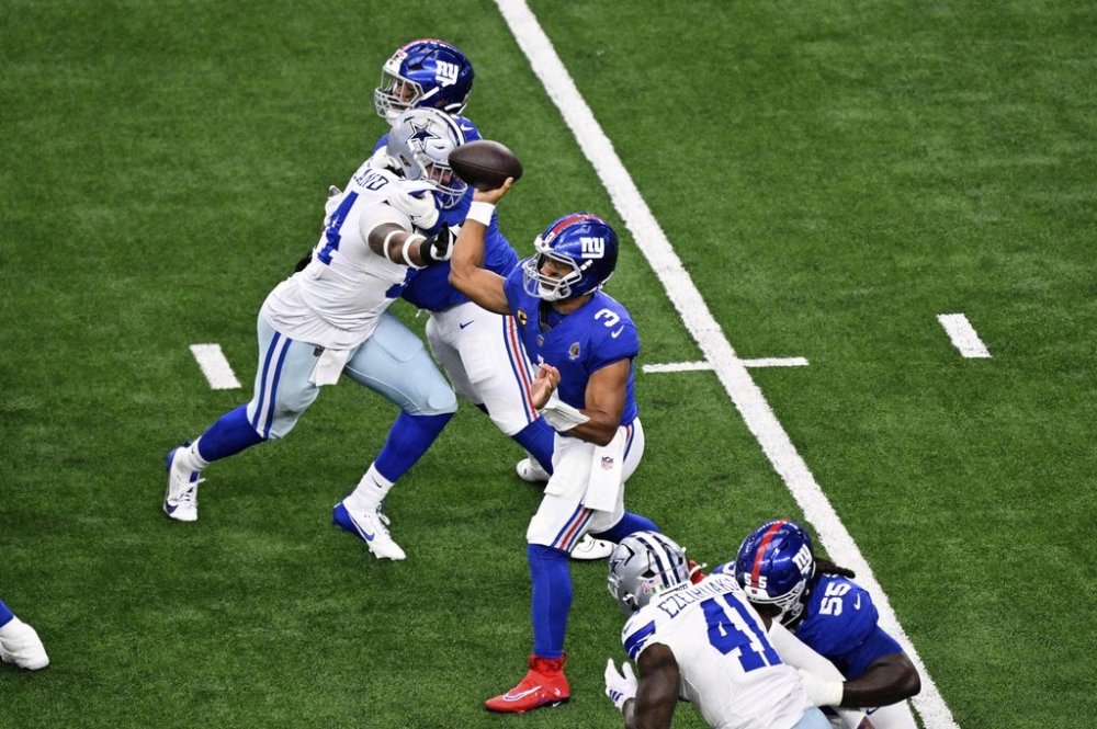New York Giants quarterback Russell Wilson (3) throws a pass under pressure from Dallas Cowboys defensive end Sam Williams (54) in the first half of an NFL football game Sunday, Sept. 14, 2025, in Arlington, Texas. (AP Photo/Jerome Miron)