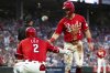 Cincinnati Reds' Matt McLain (9) and Gavin Lux (2) celebrate after McLain scored in the third inning of a baseball game against the Chicago Cubs, Saturday, Sept. 20, 2025, in Cincinnati. (AP Photo/Michael Swensen)