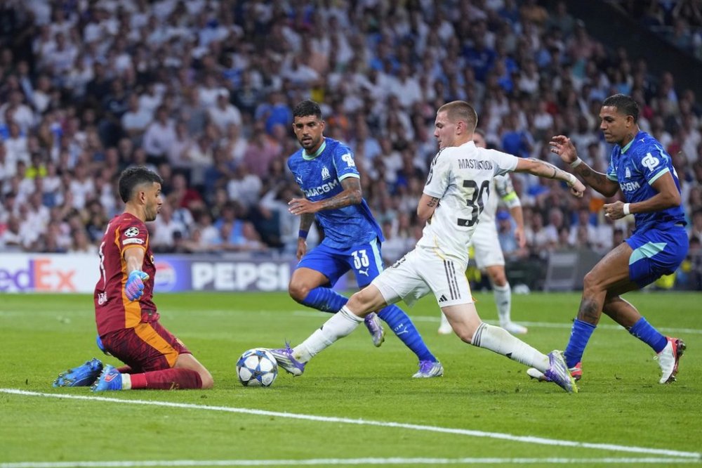 Real Madrid's Franco Mastantuono, second right, challenges Marseille's goalkeeper Geronimo Rulli, left, during a Champions League opening phase soccer match between Real Madrid and Marseille at Santiago Bernabeu stadium, in Madrid, Tuesday, Sept. 16, 2025. (AP Photo/Manu Fernandez)