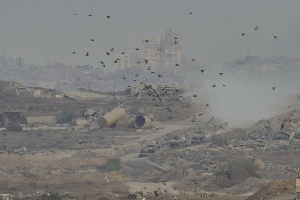 Israeli soldiers drive on their armored personnel carrier inside the northern Gaza Strip, as seen from southern Israel, Sunday, Sept. 21, 2025. (AP Photo/Ohad Zwigenberg)