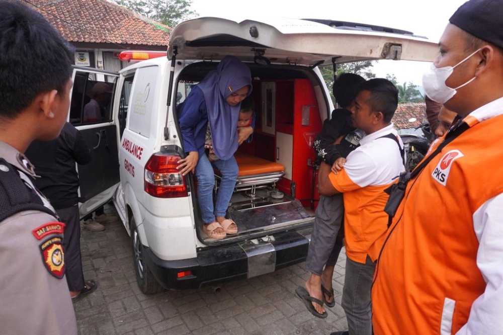 Health workers assist children who fell ill from food poisoning as they arrive in an ambulance, at Cililin Hospital in West Bandung, Indonesia, Thursday, Sept. 25, 2025. (AP Photo/Adnan Kheruma)