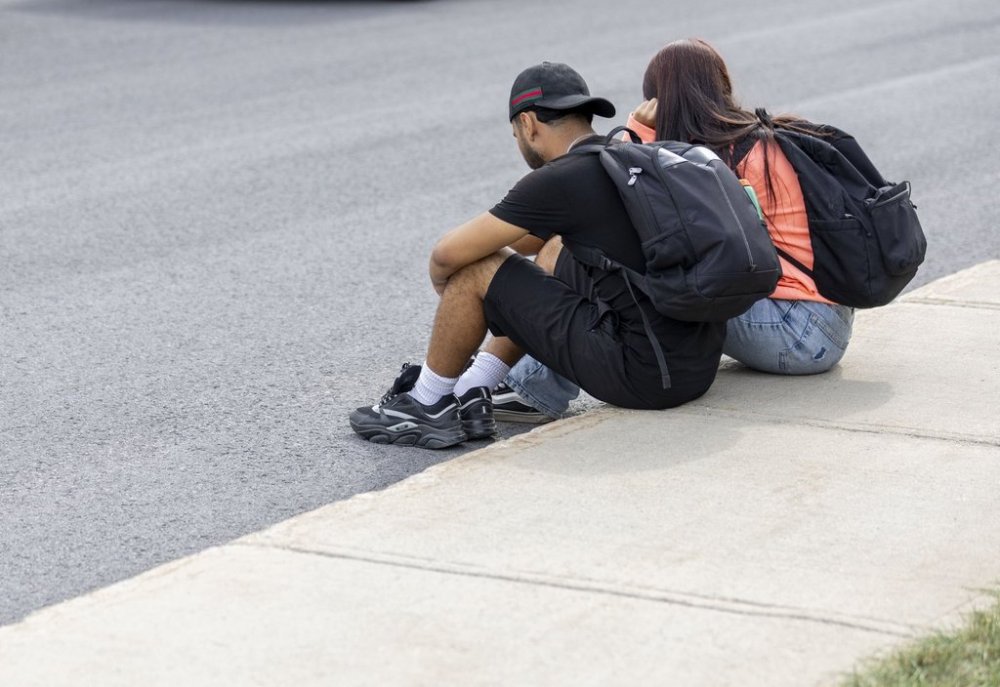 Local teenagers sit on the street where one person died after being shot by police on Montreal's South Shore of Longueuil, Que., on Monday, Sept. 22, 2025. THE CANADIAN PRESS/Christinne Muschi