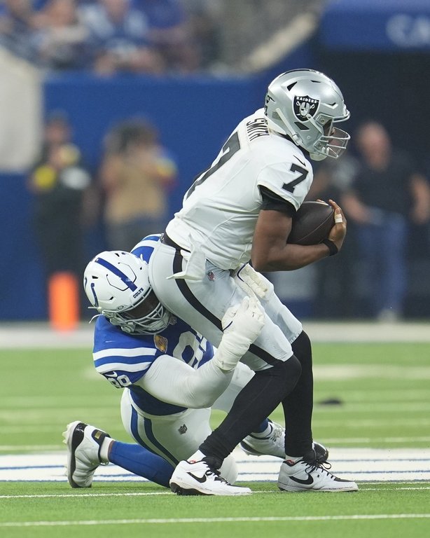 Las Vegas Raiders quarterback Geno Smith (7) is sacked by Indianapolis Colts defensive tackle Deforest Buckner (99 during the first half of an NFL football game, Sunday, Oct. 5, 2025, in Indianapolis. (AP Photo/Michael Conroy)