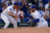 Chicago Cubs' Michael Busch, right, high-fives third base coach Quintin Berry (0) after hitting a triple during the seventh inning of a baseball game against the St. Louis Cardinals, Saturday, Sept. 27, 2025, in Chicago. (AP Photo/Erin Hooley)