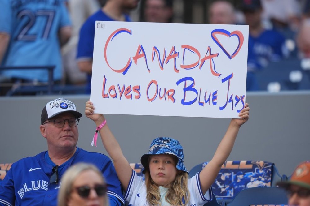 A Toronto Blue Jays fan holds up a sign ahead of the start of the American League Division Series MLB playoff series between the Toronto Blue Jays and the New York Yankees in Toronto on Saturday, October 4, 2025. THE CANADIAN PRESS/Frank Gunn