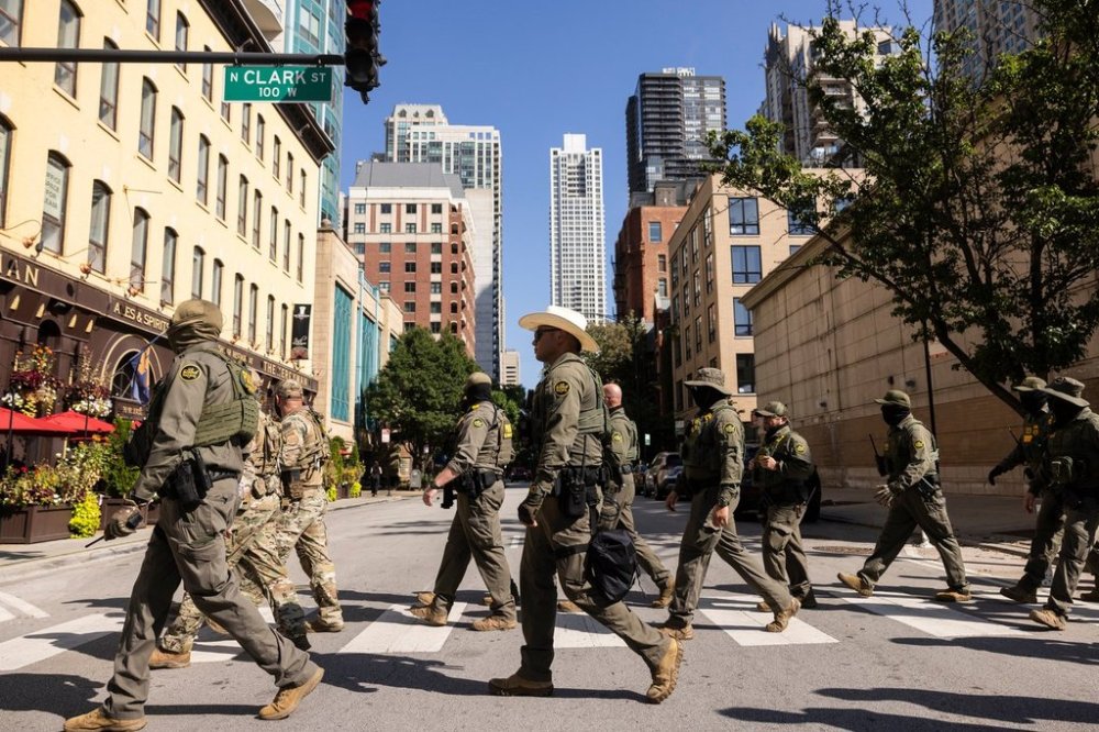 Federal agents from U.S. Immigration and Customs Enforcement and U.S. Customs and Border Protection walk north on North Clark Street in the River North neighborhood, Sunday, Sept. 28, 2025, in Chicago. (Ashlee Rezin/Chicago Sun-Times via AP)