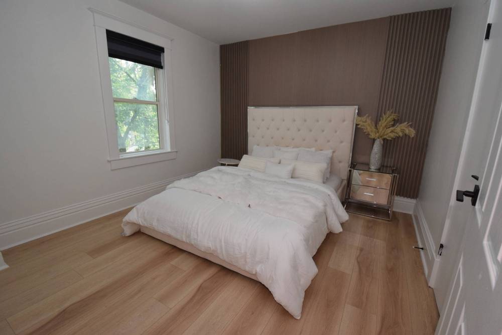 A warm wood slat feature wall provides a beautiful backdrop for the bed in the spacious primary bedroom.