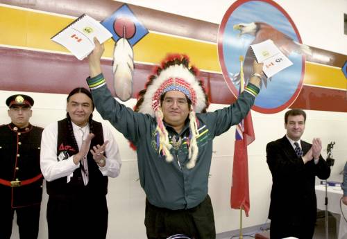 Fred Greenslade photo
                                In this 2001 photo, Chief Ken Whitecloud (centre) of Sioux Valley Dakota Nation holds up copies of the agreement in principle for self-government as Manitoba minister of Indian affairs Eric Robinson (left) and his federal counterpart, Robert Nault, applaud. The agreement came into effect in early 2014.