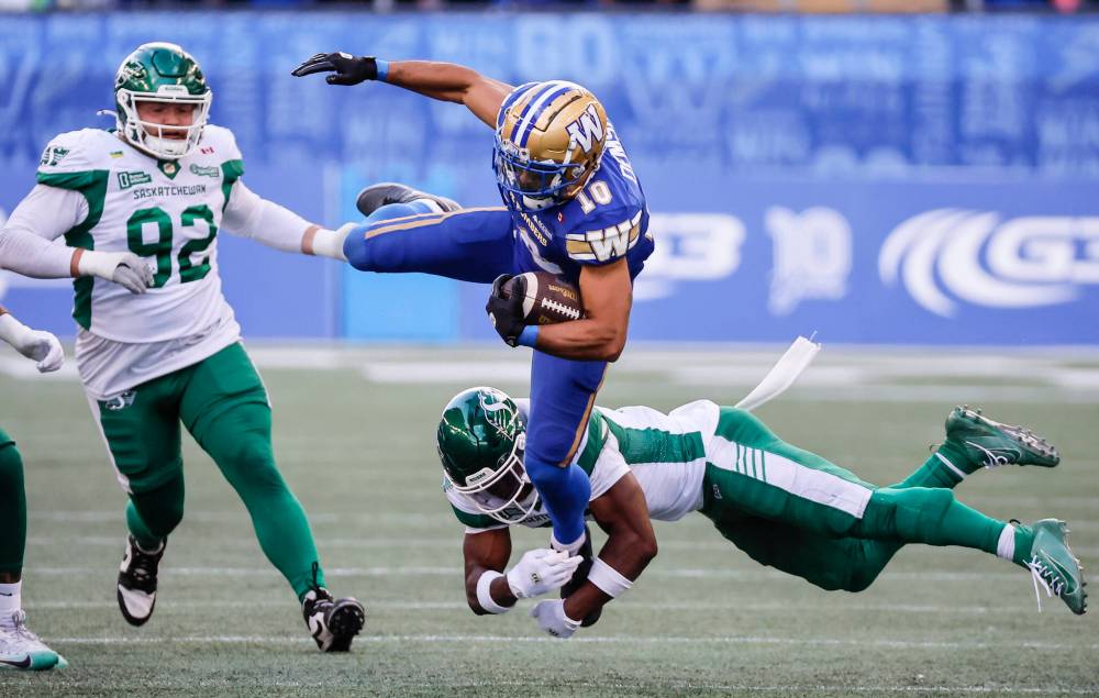 JOHN WOODS / THE CANADIAN PRESS
Winnipeg Blue Bombers' Nic Demski (10) leaps over Saskatchewan Roughriders' Kosi Onyeka (31) for the first down during second half CFL action in Winnipeg, Saturday, Sept. 6, 2025.