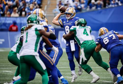 Winnipeg Blue Bombers quarterback Zach Collaros (8) gets the pass off despite pressure from Saskatchewan Roughriders’ Micah Johnson (4) during first half CFL action in Winnipeg, Saturday, Sept. 6, 2025. THE CANADIAN PRESS/John Woods