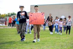 Ruth Bonneville / Free Press LOCAL - Terry Fox Walk Two grade 4 students hold sign as they walk with their classmates, grades K - 5 from Riverbend Community School as they take part in the Terry Fox Foundation Walk Friday. (No Names provided) Sept 12th, 2025
