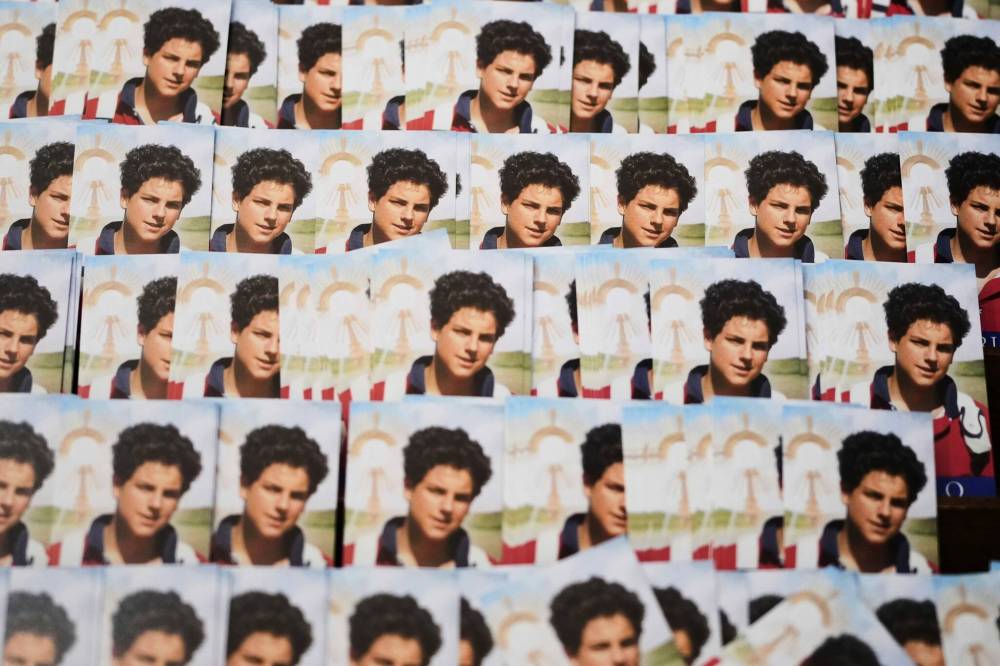 Photos of Carlo Acutis, a 15-year-old Italian boy who died in 2006 of leukemia and beatified in 2020, are displayed at the Santa Maria Maggiore church in Assisi, Italy, Wednesday, April 2, 2025. (AP Photo/Alessandra Tarantino)