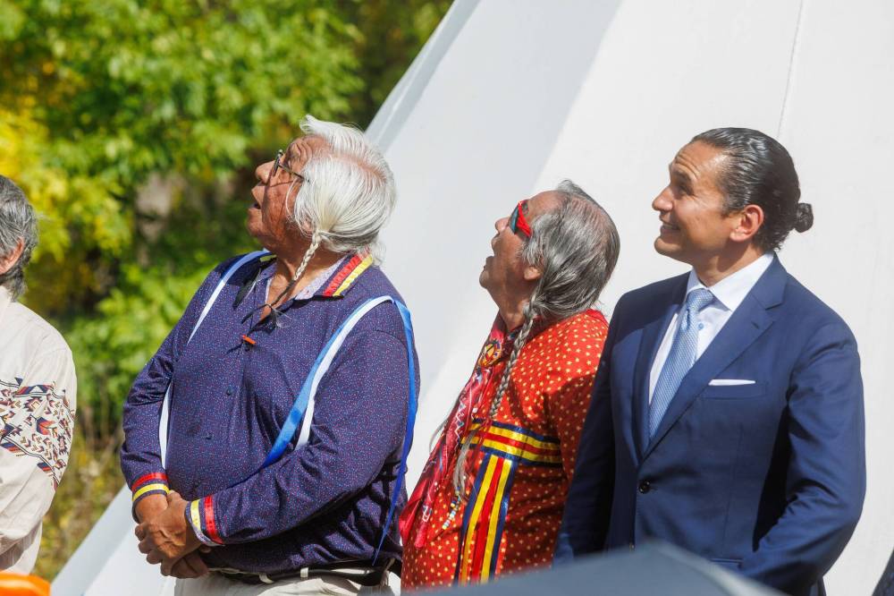 MIKE DEAL / FREE PRESS
Survivors, Keith Chiefmoon (left) and Antoine Mountain (centre), watch an eagle overhead along with Premier Wab Kinew, the minister responsible for Indigenous reconciliation, who announced that his government will be putting forward $20 million to support the construction of a permanent home for the National Centre for Truth and Reconciliation (NCTR) at the University of Manitoba during a ceremony Friday afternoon.