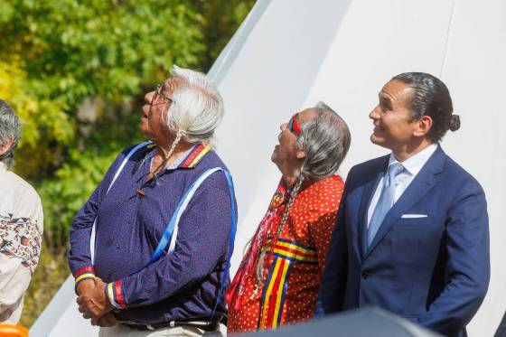 Survivors Keith Chiefmoon (left) and Antoine Mountain (centre), look up along with Premier Wab Kinew, the minister responsible for Indigenous reconciliation, announces that his government will be putting forward $20 million to support the construction of a permanent home for the National Centre for Truth and Reconciliation (NCTR) at the University of Manitoba during a ceremony on Sept. 12. (Mike Deal/Free Press files)
