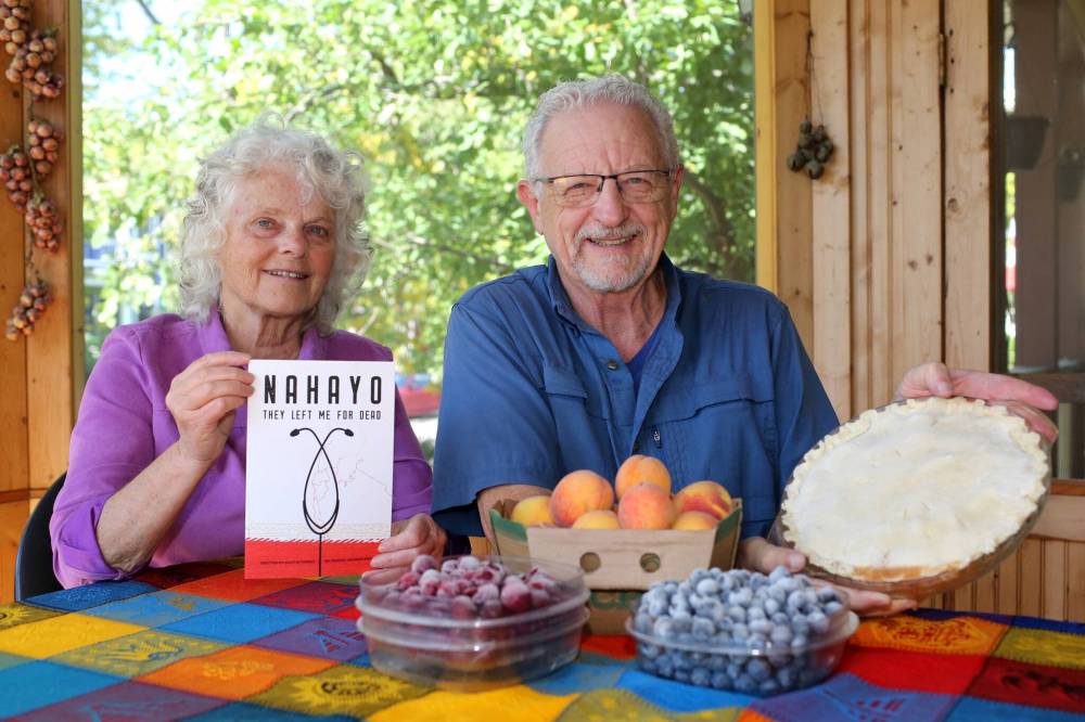Brook Jones / Free Press
Jan Schmidt, 70, (left) holds a book about Jackson Nahayo, who started the Ubuntu Clinic, while her husband, John David Pankratz, 71, displays a pie he baked.