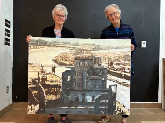 Grands ‘n’ More volunteers Jean Altemeyer and Carol Hibbert holding an oil panting by Toki Orui, included in today’s Attic pre-sale auction. (Supplied)