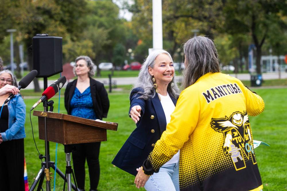 MIKAELA MACKENZIE / FREE PRESS
MLA Nahanni Fontaine hugs Manitoba Deaf Association president Shawna Joynt at the deaf flag-raising in Memorial Park on Tuesday.
